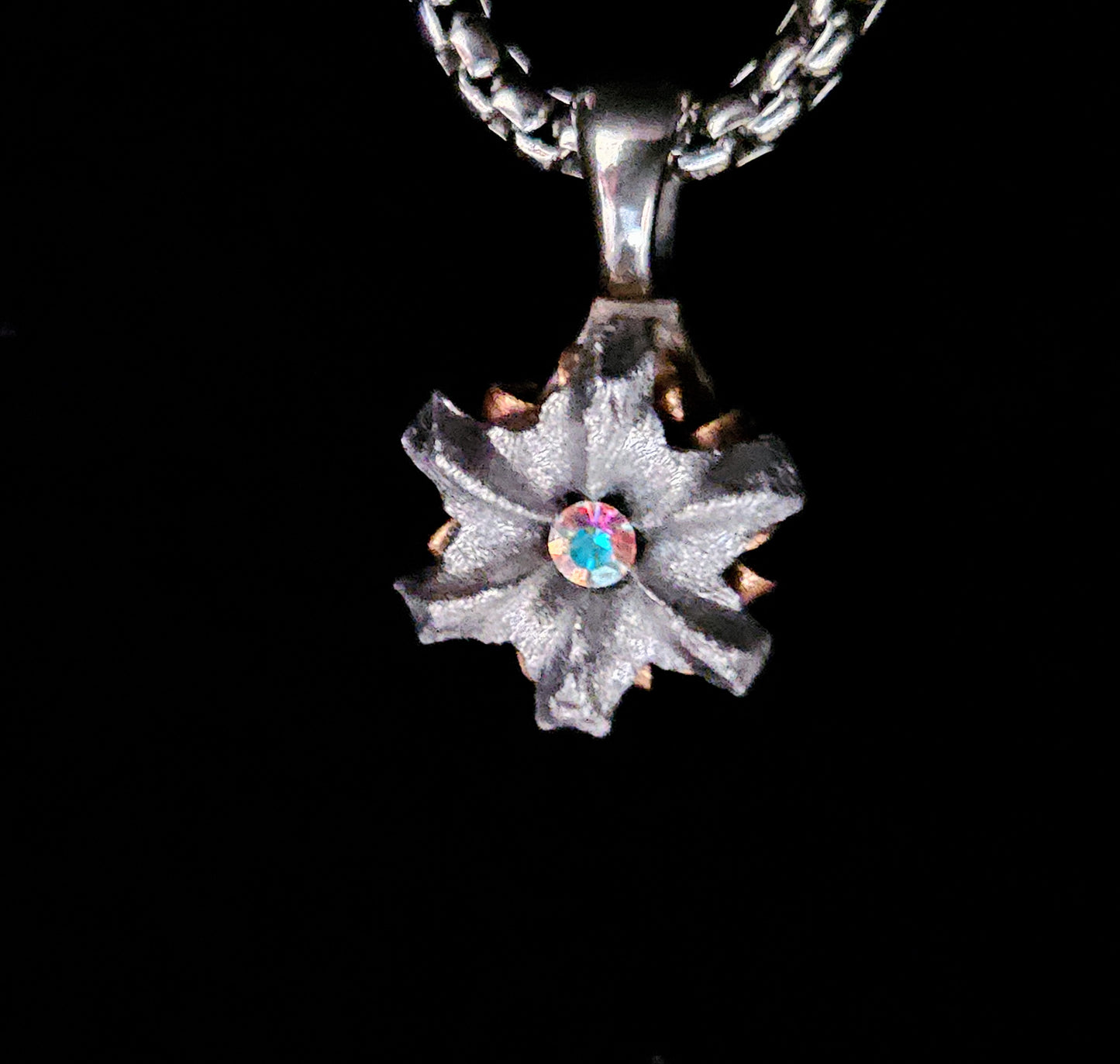 Silver pendant with a gemstone on a black background