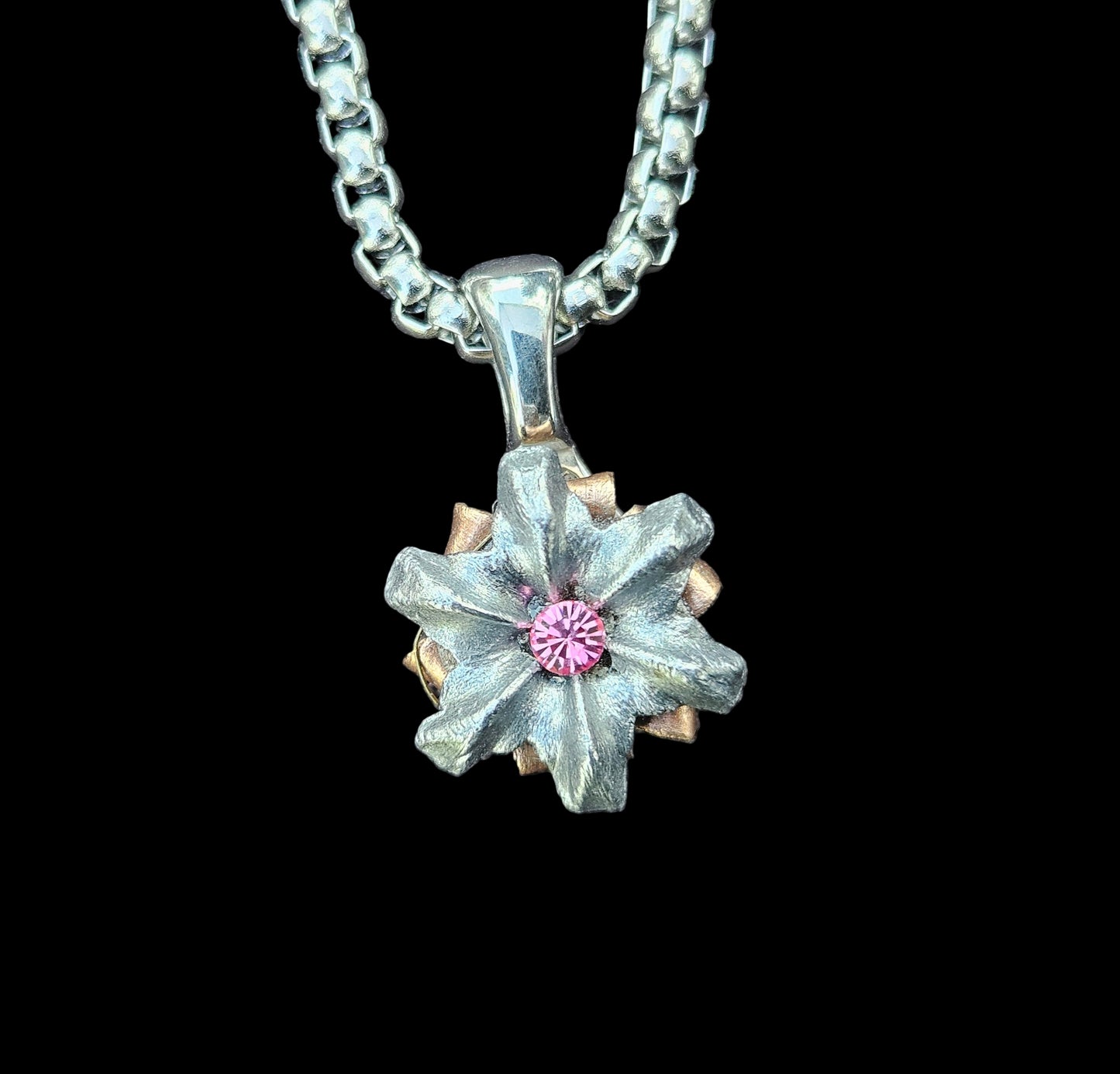 Silver necklace with a star-shaped pendant on a gray fabric background