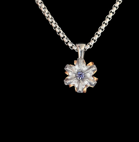 Silver necklace with a floral pendant on a black background