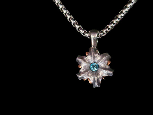 Silver pendant with a blue gemstone on a black background