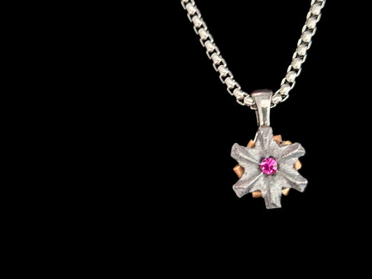 Silver necklace with a star-shaped pendant featuring a pink gemstone on a black background