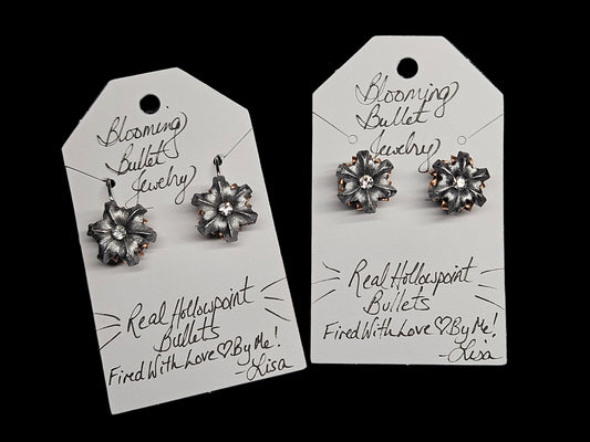 Pair of silver flower-shaped earrings on Blooming Bullet Jewelry tags.