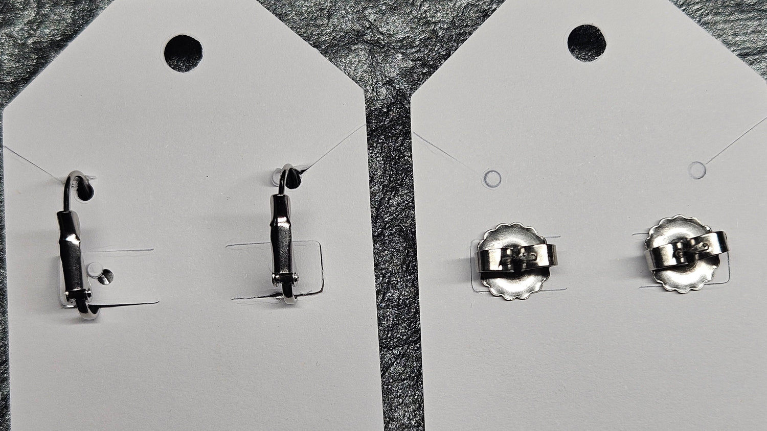 Two Pairs of silver earring backs on white earring cards