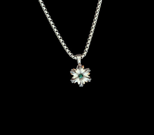 Silver necklace with a flower-shaped pendant on a black background