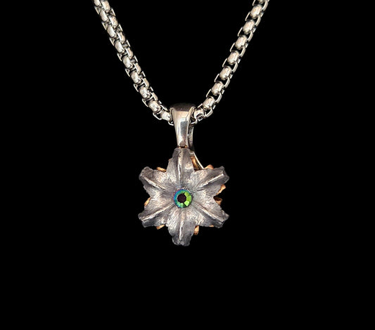 Silver flower-shaped pendant with a central gemstone on a black background