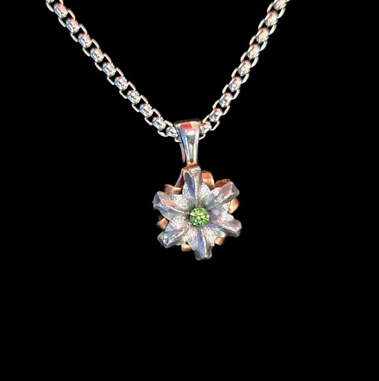 Silver pendant with a green gemstone on a black background