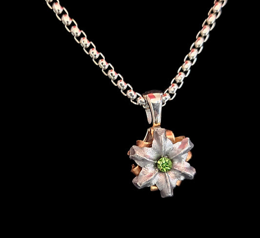 Floral pendant necklace with a green gemstone on a black background