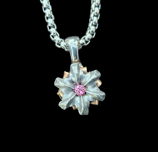 Silver necklace with a star-shaped pendant on a gray fabric background