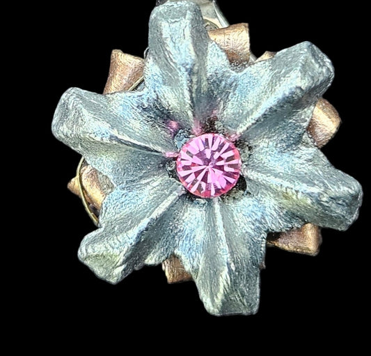 Silver necklace with a star-shaped pendant on a gray fabric background