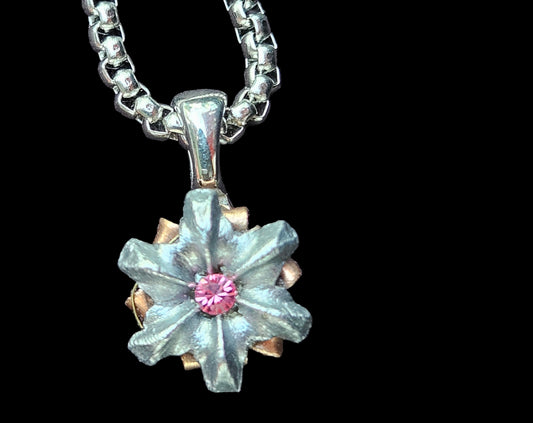 Floral pendant necklace with pink center on a black background