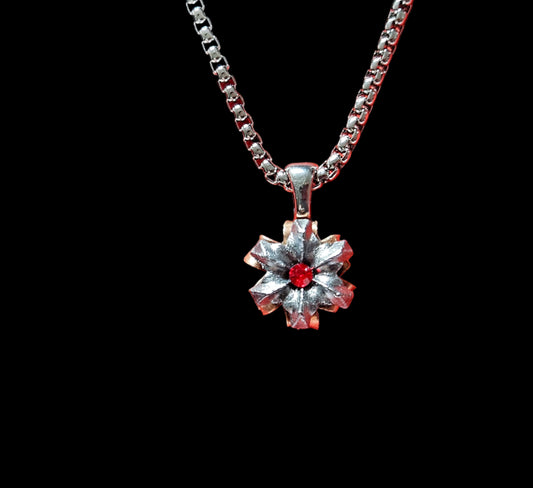 Silver necklace with a floral pendant on a red background