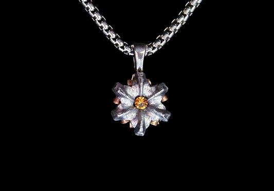Silver necklace with a star-shaped pendant on a black background
